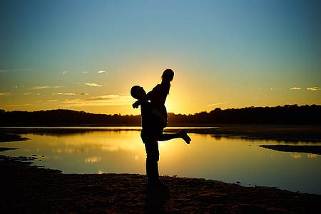 Royalty-Free photo: Silhouette of man and woman kissing by the seashore ...