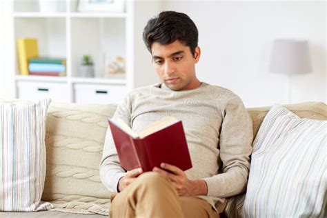 Man Sitting on Sofa and Reading Book at Home Stock Photo - Image of ...