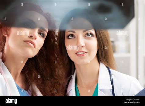 Two female medicine doctors looking at patient lungs x-ray image ...
