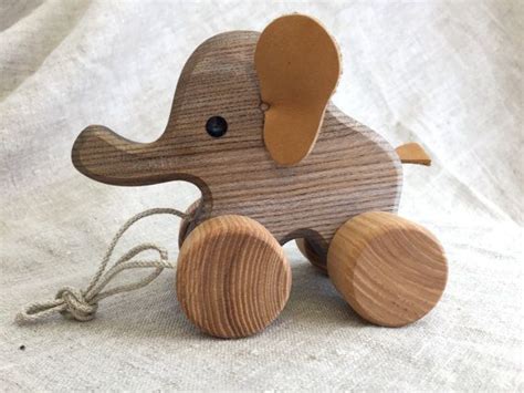 Pull along toy Elephant, a joyfully looking wooden animal on wheels ...