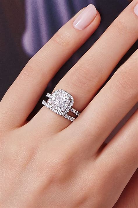 a woman's hand with two engagement rings on it