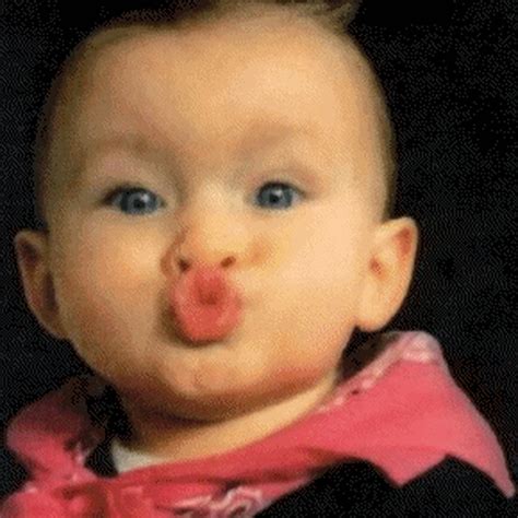 a baby wearing a pink bow tie making a funny face while sticking its tongue out