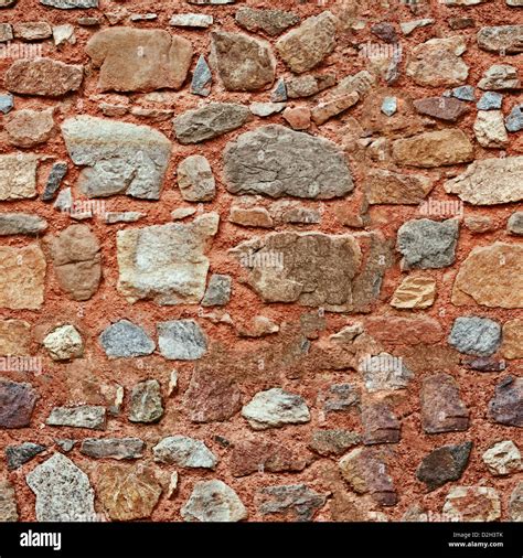 Red wall with natural different size stones - seamless texture Stock Photo - Alamy