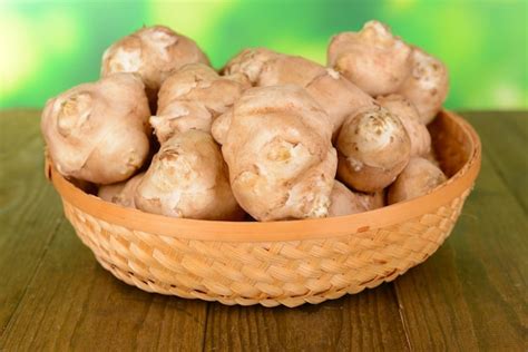 Premium Photo | Topinambur roots in wicker basket on table on bright background