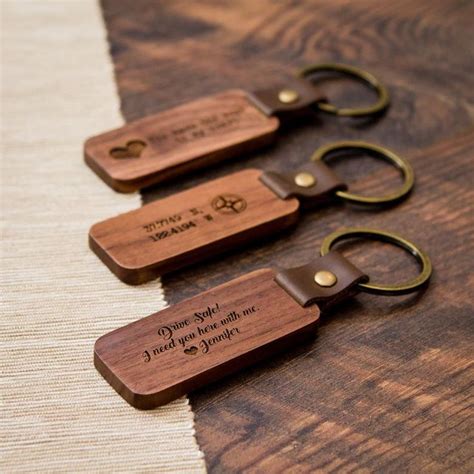 three wooden keychains with metal handles and engraved words on them, sitting on a table