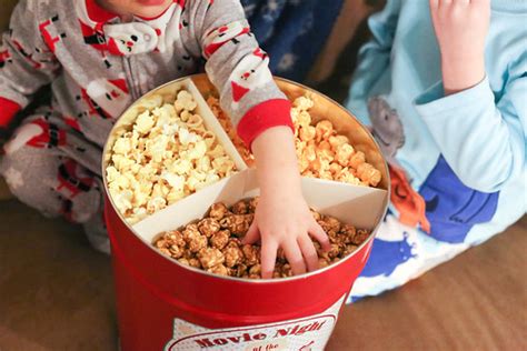 Child wearing pajamas with hand in holiday popcorn tin wth… | Flickr