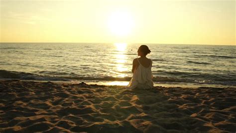 Woman Sitting On A Sand Beach In Front Of Sunset And Ocean In Summer Stock Footage Video 7596715 ...