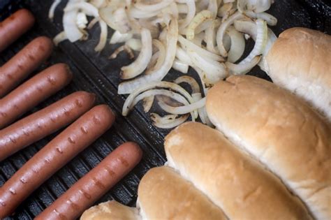 Cooking hot dog ingredients on a griddle - Free Stock Image