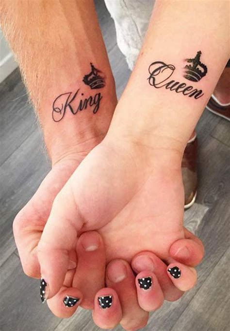 two people holding hands with tattoos on their arms and the words queen and king written in ...