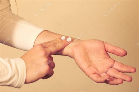 Woman checking pulse on wrist closeup — Stock Photo © Voyagerix #112217410