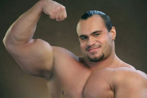 Male Bodybuilder Flexing Biceps Muscles