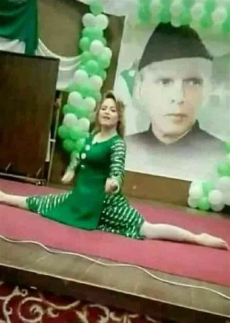 a woman sitting on top of a bed in front of a large poster and balloons