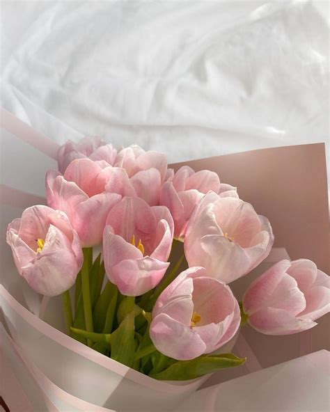 a bouquet of pink tulips sitting on top of a bed