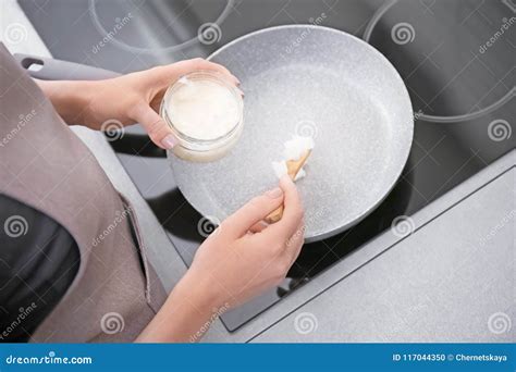 Woman Putting Coconut Oil on Frying Pan in Kitchen, Stock Photo - Image ...