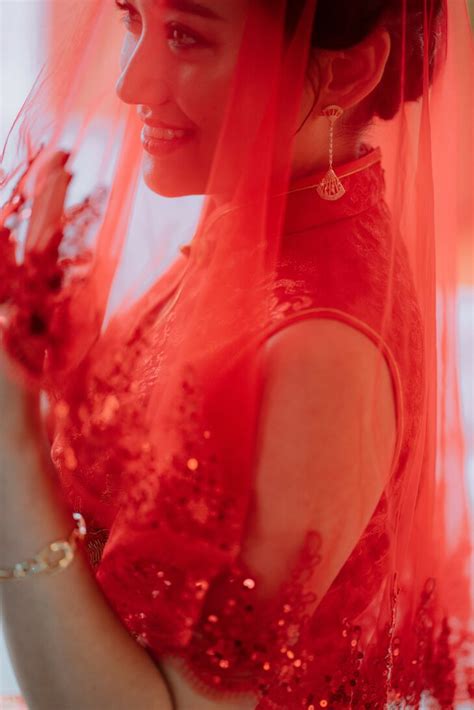 Bride Under Red Veil in Modern Red Chinese Qipao and Gold Drop Earrings