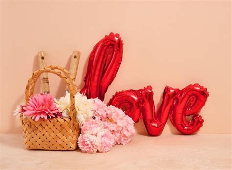 Premium Photo | Wicker decorative basket with flowers and garden tools red foil balloon in the ...