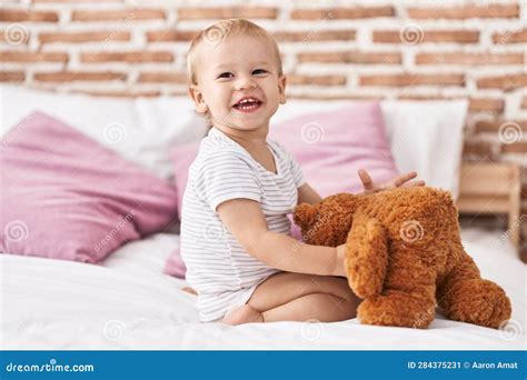 Adorable Toddler Playing with Teddy Bear Sitting on Bed at Bedroom ...