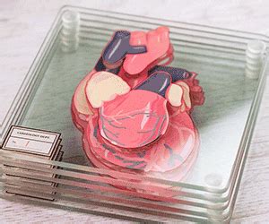 a close up of a heart shaped object in a glass container on a wooden table