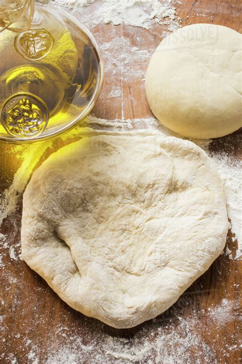 Uncooked dough, rolled out and in a ball, olive oil - Stock Photo ...