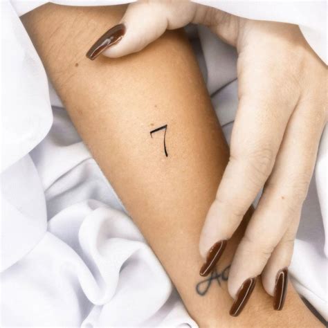 Number "7" tattoo on the forearm.