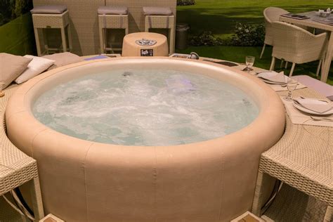 Round whirlpool with beige leather cover and matching side tables made of rattan - Creative ...