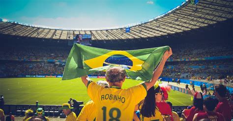 Man Raising Brazil Flag Inside Football Stadium · Free Stock Photo