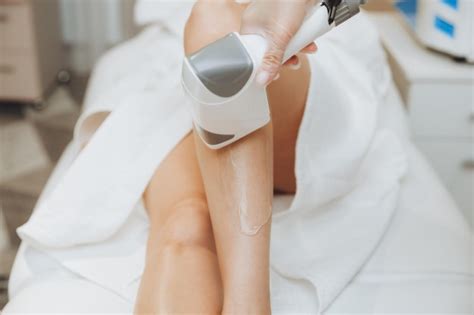 Premium Photo | Beautician removes hair on female legs with a laser ...