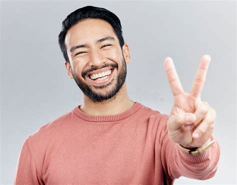Portrait, Peace Sign and Laughing Asian Man in Studio Isolated on a Gray Background. Face, V ...