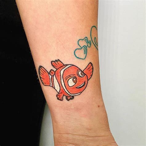 Nemo tattoo hand poked on the wrist, cartoon style.