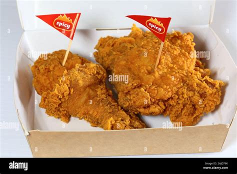 A Jollibee "Chickenjoy!" 2-piece spicy fried chicken in a paper take ...