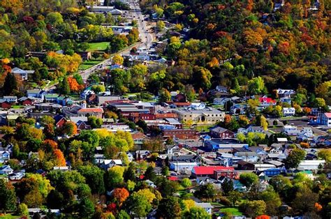 an aerial view of a small town surrounded by trees in the fall season ...