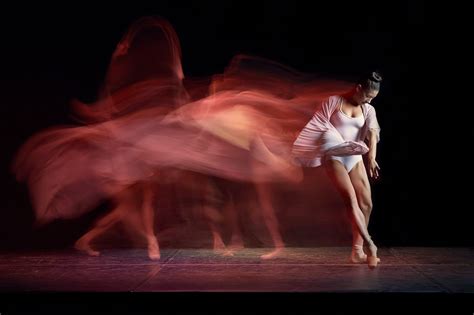 two dancers in motion on a stage with blurry lights behind them and one ...