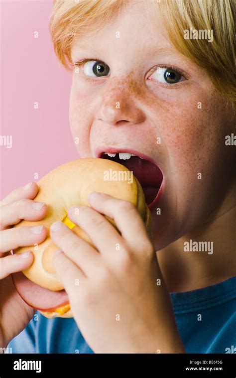 Boy eating ham and cheese sandwich Stock Photo - Alamy