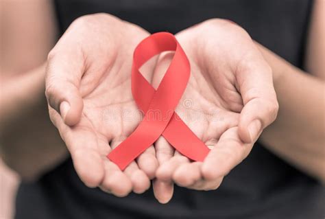 Female Hands Holding Red AIDS Awareness Ribbon. Stock Photo - Image of concept, help: 116224500