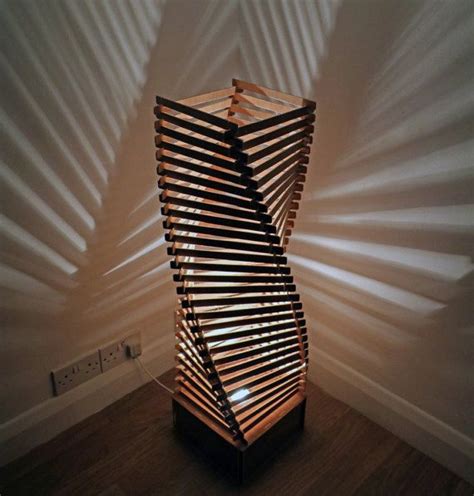 Wooden floor lamp made from a spiral of 109 interlocked wooden elements which stands around 1 ...