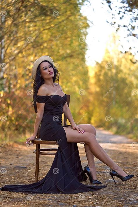 Stylish Brunette Woman Sitting on a Chair in the Middle of Autumn Park Stock Image - Image of ...