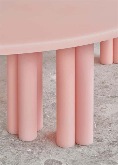 three pink stools sitting next to each other on cement floored area with concrete grounding