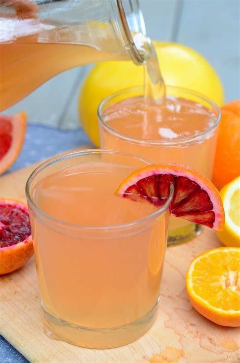 two glasses filled with orange juice sitting on top of a white table ...