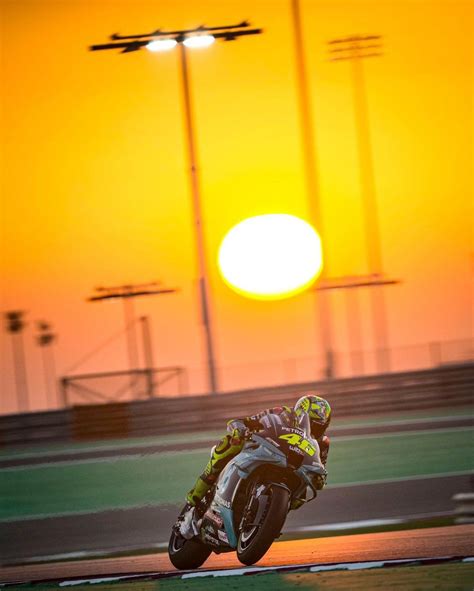 a person riding a motorcycle on a track at sunset