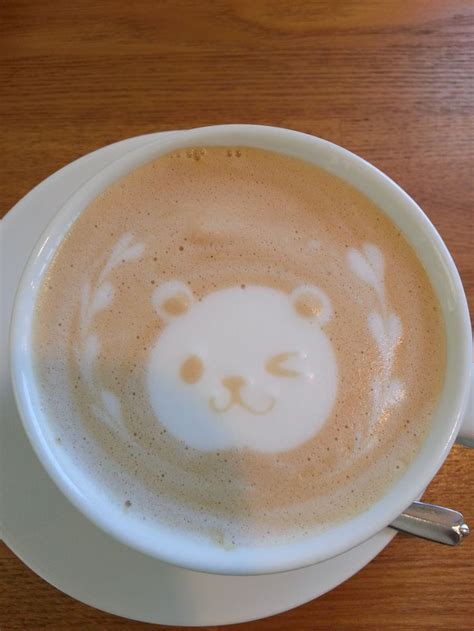 a cup of coffee with a bear drawn on it