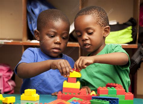 Two children playing with building blocks - Stock Image - F033/7409 - Science Photo Library