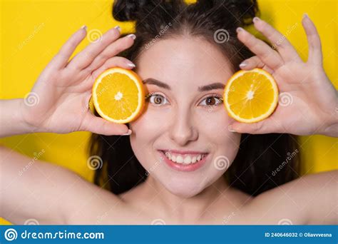 Young Brunette Woman Girl with Slice of Orange Fruit Near Skin Face on Yellow Background. Tasty ...