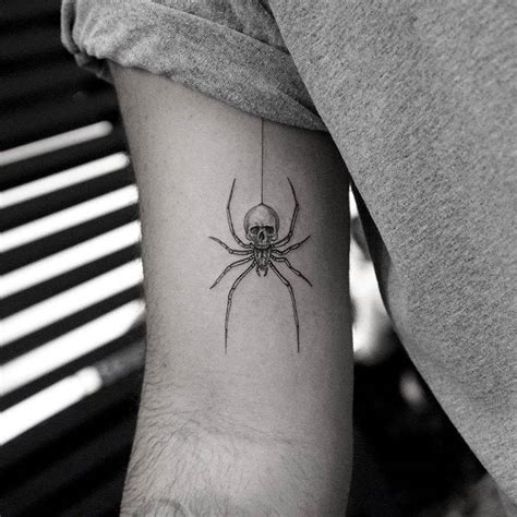 Spider skull tattoo on the inner arm.