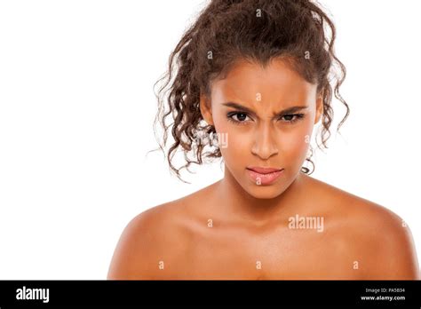 Portrait of a beautiful young dark-skinned scowling woman on a white ...