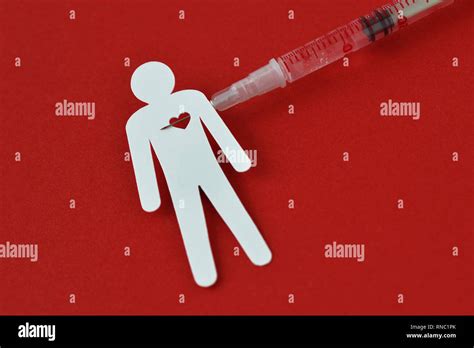 Paper man with heart and syringe on red background - Concept of drug addiction Stock Photo - Alamy