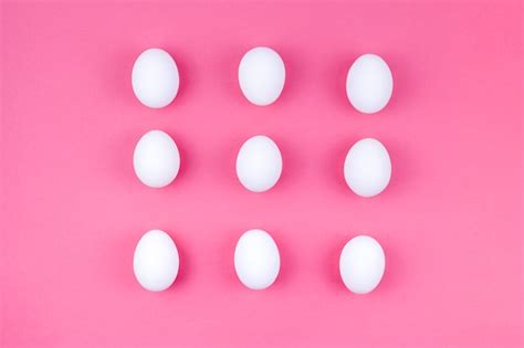 Free Photo | White chicken eggs scattered on pink table