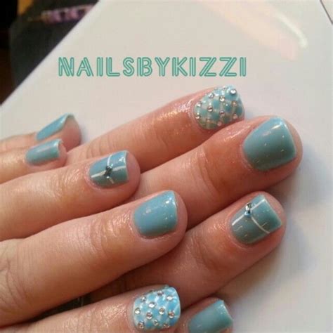 a woman's nails with blue and white designs on them