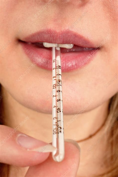 Woman with a thermometer in her mouth - Stock Image - C053/1086 - Science Photo Library