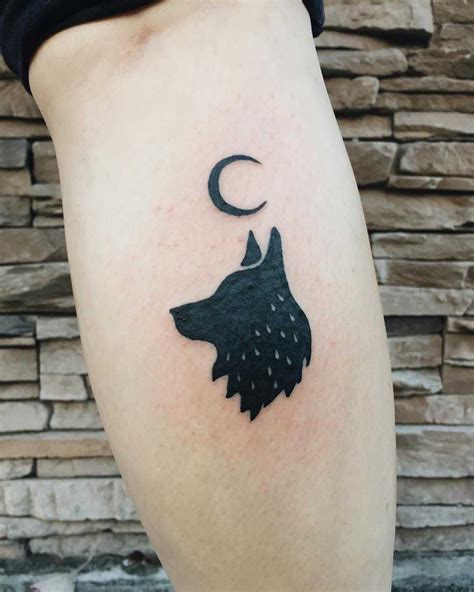 A black wolf and crescent moon tattoo inked on the right calf | Wolf and moon tattoo, Small wolf ...