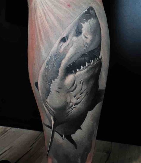 a man's leg with a black and white tattoo of a shark on it